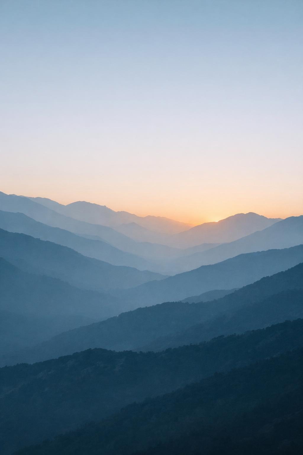 AI aesthetic phone wallpaper — misty layered mountain range at dawn in muted blue-grey with warm amber accent, vertical 4K